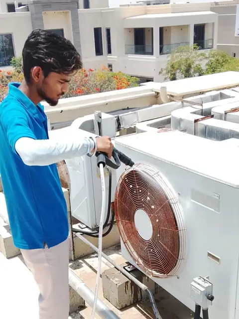 Technician checking outdoor AC condenser units in Dubai