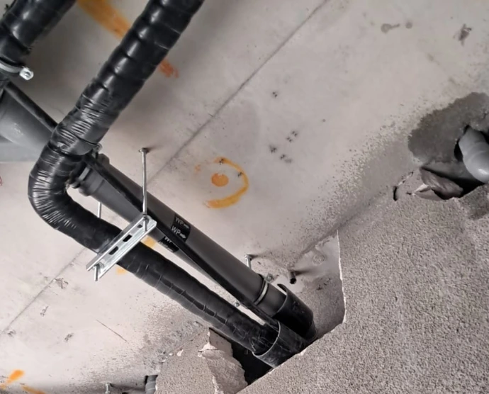 Insulated AC drain and service pipework fixed to a ceiling